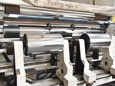 Technicians operating Vacuum Metallizer Machines in factory environment